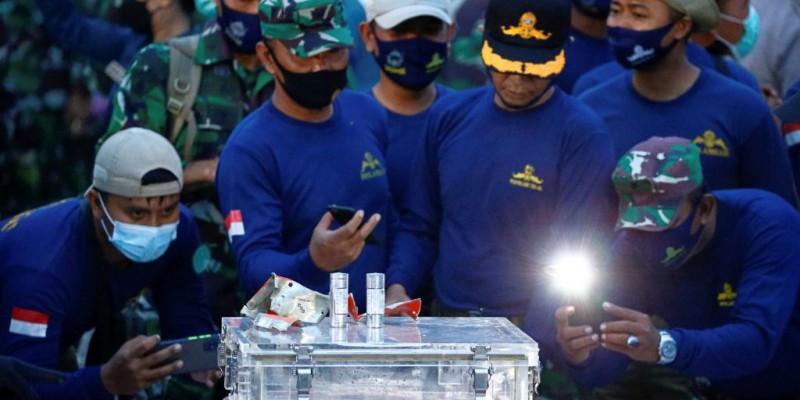 Prajurit TNI memotret Flight Data Recorder (FDR) pesawat Sriwijaya Air SJ 182 yang jatuh di perairan Pulau Seribu, di Dermaga JICT, Jakarta, Selasa (12/1). Foto: Ajeng Dinar Ulfiana/REUTERS